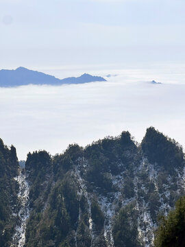 View of the snow-covered granite peaks of Huangshan rising above a dense sea of clouds under a clear sky in Huangshan City, Anhui, China.
