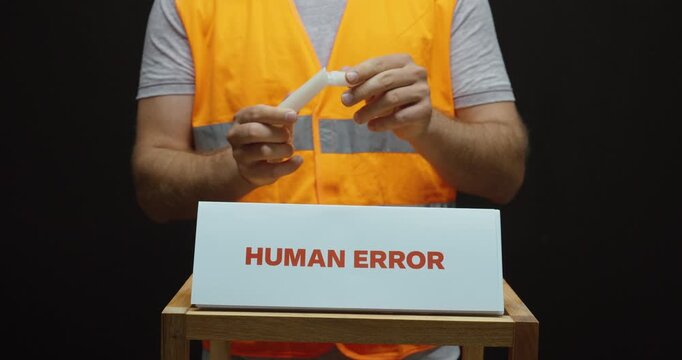 Worker breaking a component beside a &ldquo;Human Error&rdquo; sign, illustrating workplace mistakes, accidental damage, quality issues and manufacturing failure.