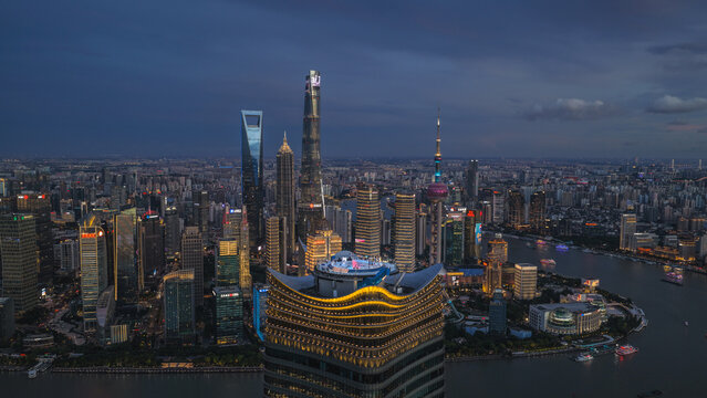 Aerial view of Sinar Mas Plaza with the illuminated Shanghai skyline, including Shanghai Tower and Oriental Pearl Tower, reflecting over the Huangpu River in Shanghai, Shanghai, China.