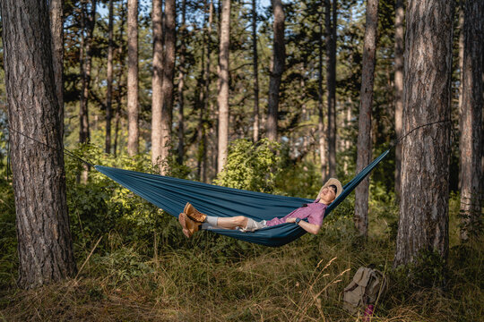 Woman relaxing in hammock enjoying nature in forest
