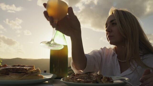 Young Woman Enjoys Federweisser young wine served with Onion tart Zwiebelkuchen. Rhine Valley terraced vineyards Germany