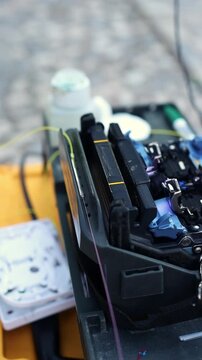 A man is taking a spliced optical fiber from the heating oven and putting it aside. Fiber optic splicing close-up