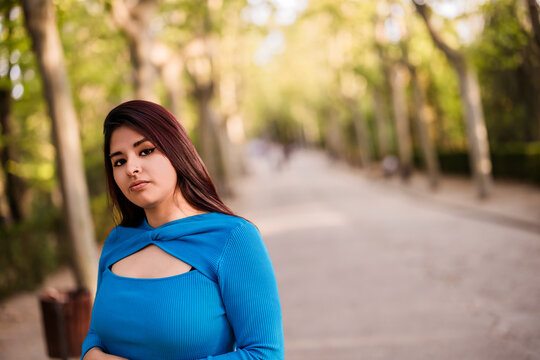 Gen z latina woman relaxing in green park