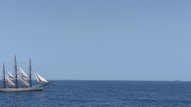 Aerial view of a three-masted sailing ship with sails sailing in the Atlantic Ocean. 