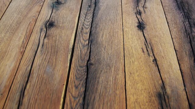 Close up camera motion over a large treated wooden board, highlighting detailed natural wood grain, cracks, and rustic timber texture.