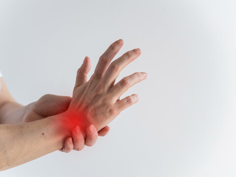 A woman suffers from wrist pain. The source of the pain is depicted as a red spot.