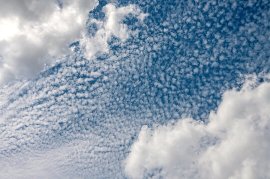 Altocumulus clouds pattern across bright blue sky background