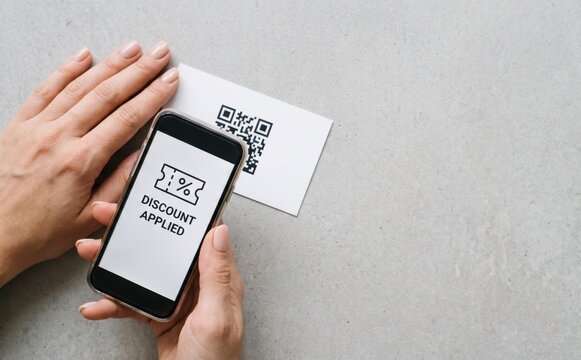 Smartphone scanning QR code on card with discount applied screen concept