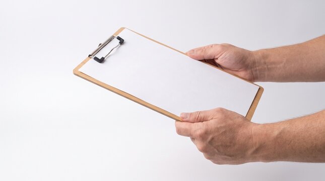 A person holding a clipboard with a blank white sheet of paper, ready for notes or data entry.