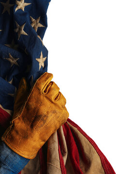 Worn work glove holding the American flag. Symbolic of hardworking blue collar workers, USA industries, pride in products Made in United States of America, or to celebrate US Labor Day. Isolated png.