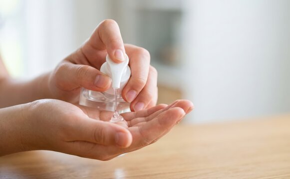 Person applying hand sanitizer gel to clean and disinfect hands to prevent germs and bacteria