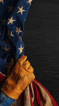 Work glove pulling the American flag back like a curtain. Symbolic of hard working blue collar workers, pride in American manufacturing or products Made in USA, or to celebrate US Labor Day.