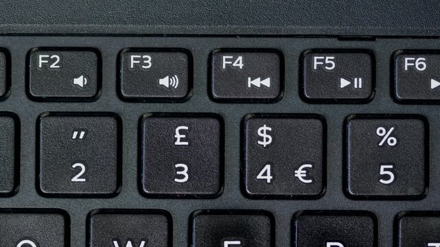 close up computer keyboard with a key. top View Finger Pressing Number 4 Buttons Keyboard dollar sing. Finger pressing an button on alluminium keyboard with black copy space on top.