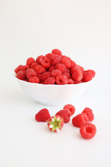 A close‑up of a red raspberry on a white background. © Мария Чепрасова