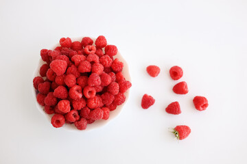 A close‑up of a red raspberry on a white background. © Мария Чепрасова