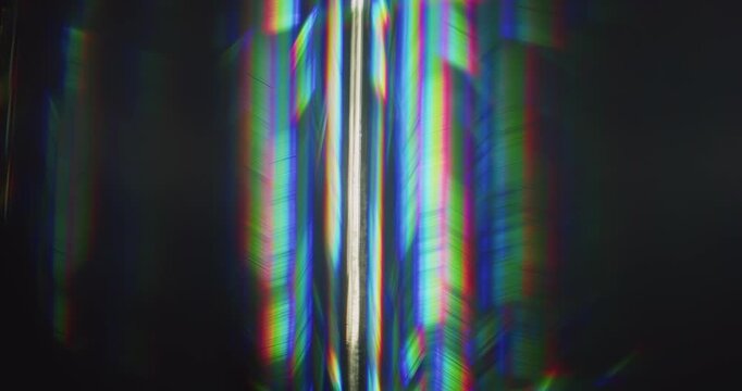 Light ray shining into a glass prism causing an optical effect of a dazzling rainbow of sparkling lights. Lighting reflect creating a visual of a burst of streaks in brilliant shining colors. Loop.