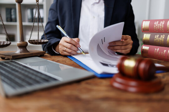 Legal professional reviewing documents at office desk, symbolizing justice and law enforcement