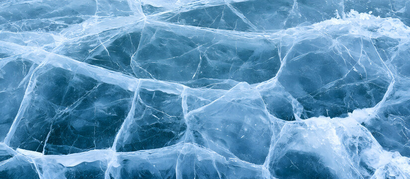 In the background, a lake is frozen and shows textured, cold ice with cracks.