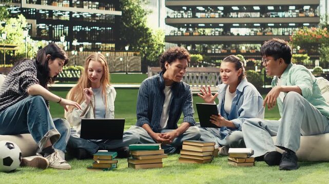 Woman student discusses project notes with classmates near an open laptop on a university campus bench, supporting peer tutoring, collaborative group study, academic teamwork and project work.