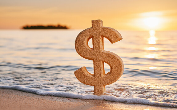 A textured dollar sign symbol stands upright on wet sand near the ocean shoreline during a warm golden sunset with gentle waves rolling in.