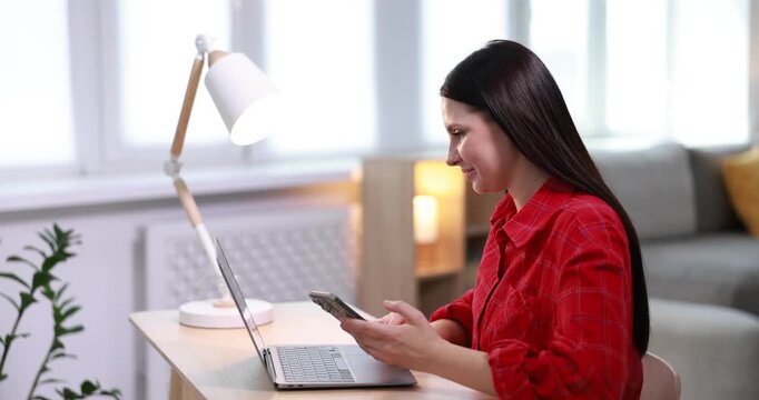 Online store. Woman using laptop and cat at wooden table indoors
