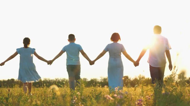 happy family, parents man woman holding children hands sunset park, mother father parents kid outdoors nature, children holding hands at sunset, kids celebrating in a summer meadow, family unity in