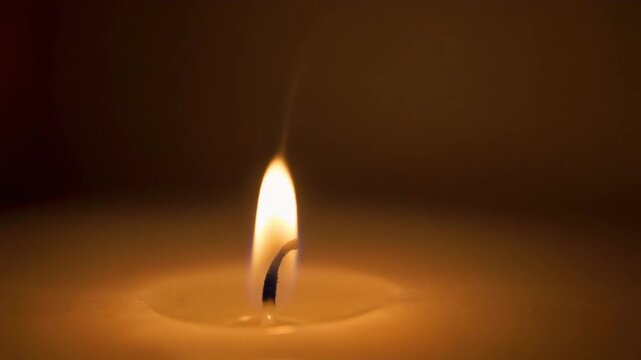 Close Up Candle Flame with Warm Glow on Dark Background
