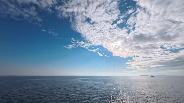 Scenic marine landscape background footage featuring radiant sunlight, cloud formation, and rich water texture
