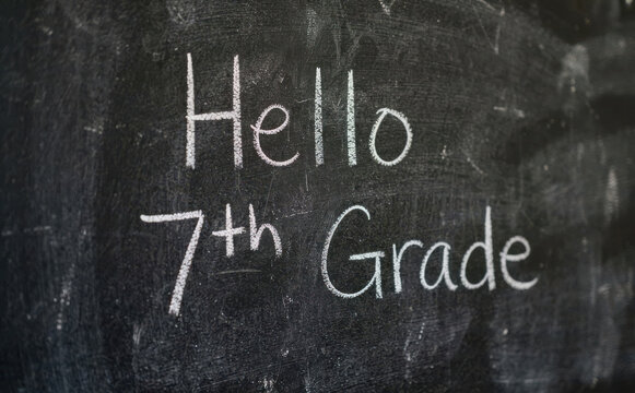 Hello 7th Grade chalkboard writing for education concept and back to school theme in classroom setting