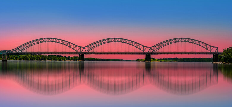 Arching steel bridge and water reflection panorama over Connecticut River at sunset