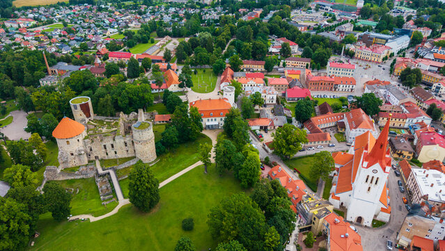Aerial view of Cesis Castle ruins and the historic St. John's Church surrounded by lush green parks and traditional red-roofed buildings in Cesis, Cesis Municipality, Latvia.
