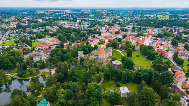 Aerial view of Cesis Castle surrounded by lush green parks, historic stone ruins, and the charming townscape of Cesis, Cesis Municipality, Latvia.