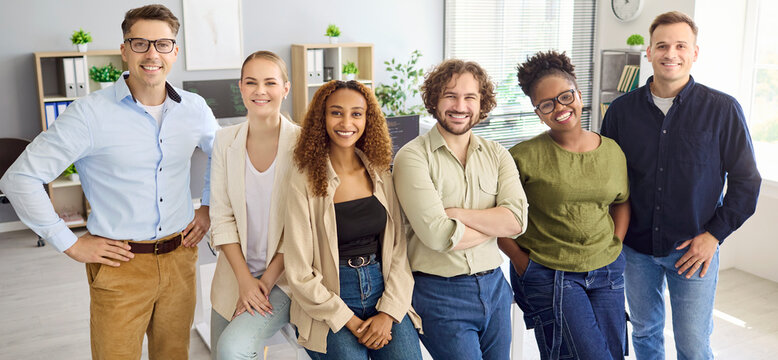 Business team colleagues in a bright office. Smiling coworkers show confidence and teamwork in a portrait, celebrating diversity among professionals in a workplace. Clear team success in business.