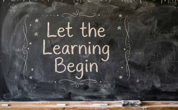 Let the learning begin written on a dark chalkboard with white chalk, concept for education, school, and classroom motivation