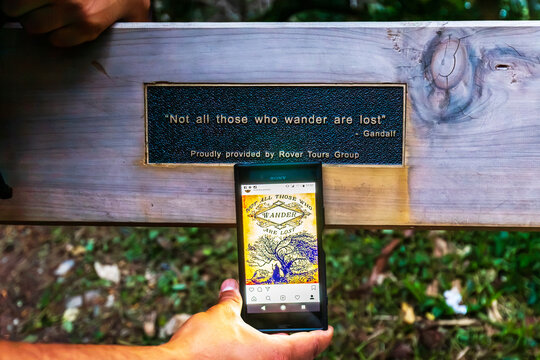 A wooden plaque featuring a famous wanderer&rsquo;s quote sits above a smartphone showing the same message at Mount Victoria in Wellington, New Zealand