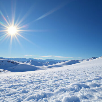 Snowy mountain landscape under bright sun with clear blue sky and distant peaks creating peaceful winter scene