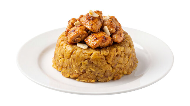 Traditional mofongo with fried chicken and garlic, mashed green plantains on white plate, Caribbean cuisine food photography