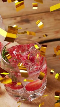 Animation of confetti falling over glasses of water with strawberries