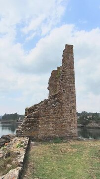 Remnants of the medieval west catoira towers, a historical fortification and cultural interest site located on the banks of the ulla river in galicia, under a picturesque cloudy sky