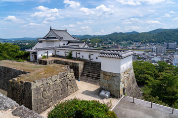The reconstructed Bitchu Yagura turret and historic stone walls of Tsuyama Castle (Kakuzan Park) in Okayama, Japan. © hit1912