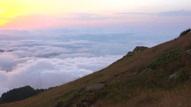 Bolivia sunrise reveals high peaks and a meadow ridge above a cloud inversion.