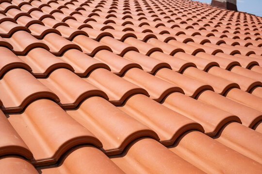 New terracotta clay roof tiles closeup texture pattern background on residential building