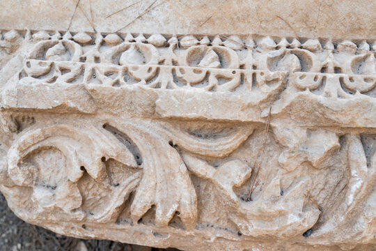 Closeup of ancient Roman marble relief carving with floral acanthus leaf decoration at archaeological site