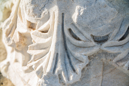 Closeup of ancient Roman marble relief carving with floral acanthus leaf decoration at archaeological site
