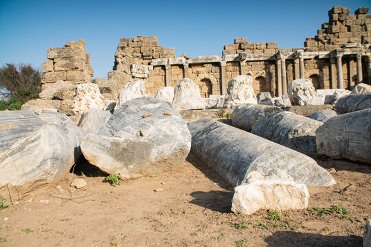 Fallen ancient Roman marble columns and Corinthian capitals scattered at Side archaeological site in Turkey