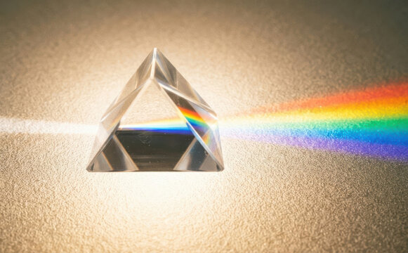 Glass prism dispersing white light into a rainbow spectrum showcasing optical physics and refraction concepts for scientific education and laboratory design backgrounds