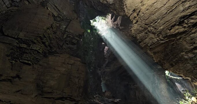 Sunlight Rays Inside Lush Green Cave
