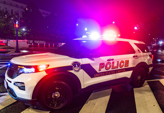 United States Capitol Police SUV at Night. Capitol Police Vehicle with Flashing Lights. Police SUV on City Street. Emergency Police Lights at Night.