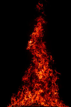 Flame under blazing firelight. Flame above texture. Flame across black background. Flame around heat. Flames burn. Fire glows. Burn continues.