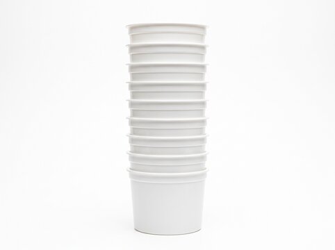Stack of white disposable paper cups for hot beverages like coffee or tea isolated on a clean white background
